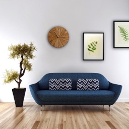 Nowoczesny salon z niebieską sofą poduszkami z deseniem w zyg-zak oraz dekoracjami ściennymi i drewnianym zegarem